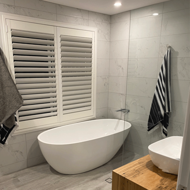 Bathroom with deep bathtub and tiled walls